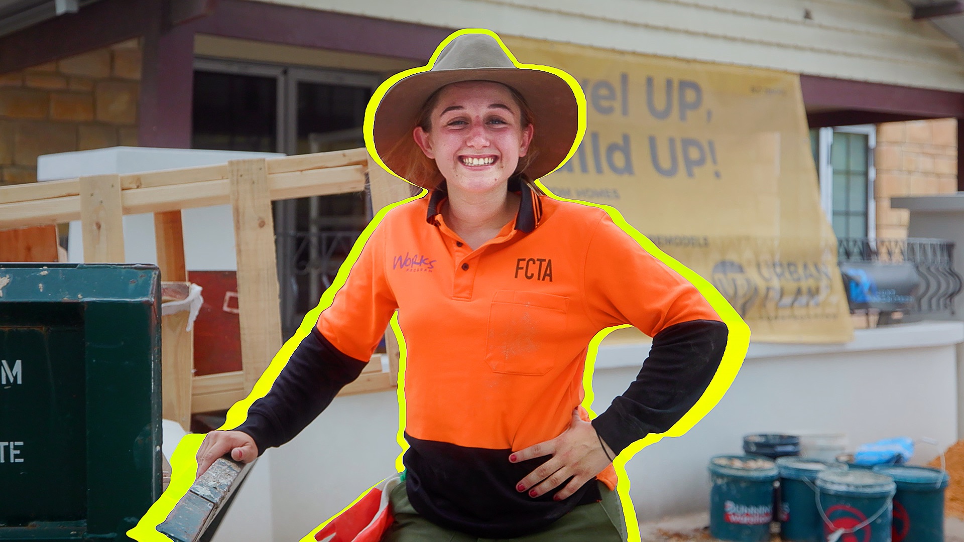 Trade working standing in front of a construction site wearing orange hi visibility clothing